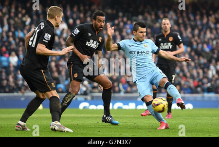 Sergio Aguero von Manchester City schießt beim Barclays Premier League-Spiel im Etihad Stadium in Manchester an Michael Dawson von Hull City (links) und Tom Huddlestone von Hull City vorbei. Stockfoto