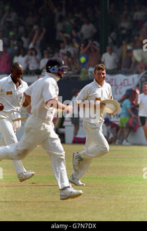 Englands Michael Atherton (r) und Chris Lewis (l) laufen vor Der Platz triumphiert nach dem Gewinn des vierten Tests Stockfoto