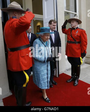 Beamte der Royal Canadian Mounted Police (RCMP) grüßen Königin Elizabeth II., als sie nach einem offiziellen Besuch abreist, um das neu renovierte Canada House im Zentrum von London wieder zu eröffnen. Stockfoto