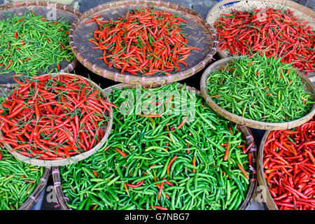 Eine Anordnung von roten und grünen Thai Chili Peppers in einem asiatischen Markt in Thailand. Stockfoto