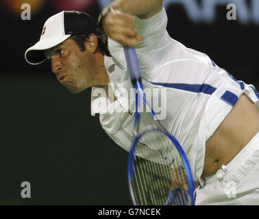 Tennis - Australian Open 2005 - zweite Runde der Herren. Greg Rusedski aus Großbritannien dient Andy Roddick aus den USA Stockfoto