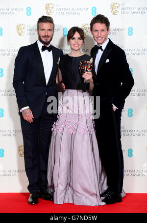 Eddie Redmayne und Felicity Jones zusammen mit Moderator David Beckham (links) mit dem Outstanding British Film Award for the Theory of Everything bei den EE British Academy Film Awards im Royal Opera House, Bow Street in London. DRÜCKEN Sie VERBANDSFOTO. Bilddatum: Sonntag, 8. Februar 2015. Siehe PA Geschichte SHOWBIZ BAFTA. Bildnachweis sollte lauten: Dominic Lipinski/PA Wire Stockfoto