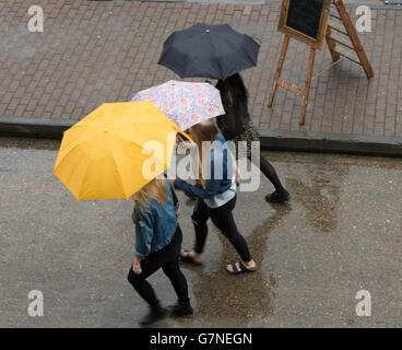 Vogelperspektive des Menschen, mit bunten Sonnenschirmen, gehen im Regen im Londoner East End Stockfoto