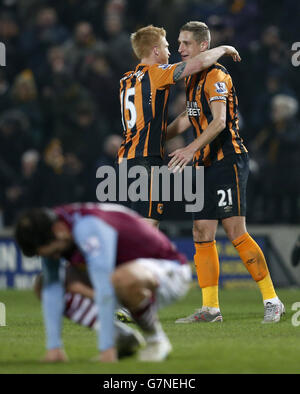 Michael Dawson (rechts) und Paul McShane von Hull feiern, wie Joe Cole von Aston Villa nach dem Spiel der Barclays Premier League im KC Stadium, Hull, niedergeschlagen ist. Stockfoto