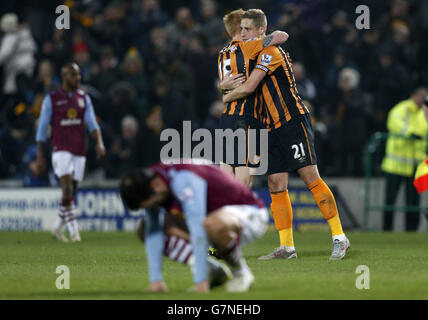 Michael Dawson (rechts) und Paul McShane von Hull feiern, wie Joe Cole von Aston Villa nach dem Spiel der Barclays Premier League im KC Stadium, Hull, niedergeschlagen ist. Stockfoto