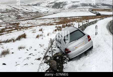 Am Butterwbs Pass in der Nähe von Hawes in North Yorkshire wurde ein Auto von der Straße losgelassen, da der Schneefall am Wochenende in vielen nördlichen Teilen Großbritanniens zu einem winterlichen Start in die Arbeitswoche führt. Stockfoto