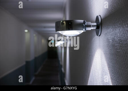 Wandleuchten im dunklen Flur eines Hotels. Stockfoto