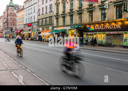 Radfahrer fahren vorbei an Geschwindigkeit entlang einer Straße in Kopenhagen im Laufe des Abends pendeln nach Hause. Stockfoto