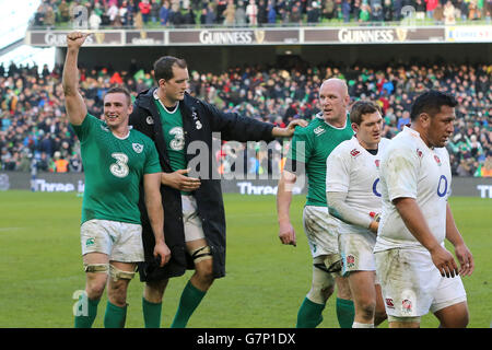 Die Engländer Mako Vunipola (rechts) und Alex Goode (zweite rechts) stehen depriziert, als die Irlands Peter O'Mahony, Devin Toner und Paul O'Connell (links in der Mitte) ihren Sieg nach dem Spiel während des RBS Six Nations-Spiels im Aviva Stadium, Dublin, feiern. DRÜCKEN SIE VERBANDSFOTO. Bilddatum: Sonntag, 1. März 2015. Siehe PA Story RUGBYU Irland. Bildnachweis sollte lauten: Niall Carson/PA Wire. EINSCHRÄNKUNGEN: Keine kommerzielle oder werbliche Nutzung ohne vorherige Zustimmung von IRFU. Keine Änderungen oder Eingriffe. Für weitere Informationen rufen Sie bitte +44 (0)115 8447447 an. Stockfoto