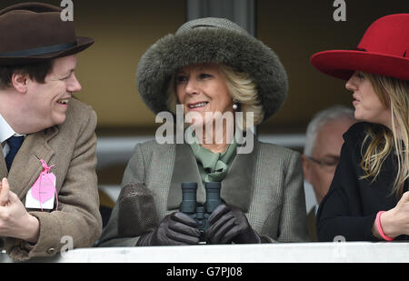 Die Herzogin von Cornwall (Mitte) beobachtet die Hürde der Neptune Investment Management Novizen mit Sohn Tom Parker-Bowles (links) und Tochter Laura Lopes (rechts) am Ladies Day während des Cheltenham Festivals auf der Pferderennbahn in Cheltenham. Stockfoto