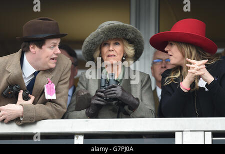 Die Herzogin von Cornwall (Mitte) beobachtet die Hürde der Neptune Investment Management Novizen mit Sohn Tom Parker-Bowles (links) und Tochter Laura Lopes (rechts) am Ladies Day während des Cheltenham Festivals auf der Pferderennbahn in Cheltenham. Stockfoto