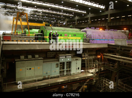 Der stellvertretende erste Minister John Swinney (Mitte) spricht mit dem Stationsleiter Lee Warren (rechts) in der Turbinenhalle während eines Besuchs im Kraftwerk Longannet in Fife. Stockfoto