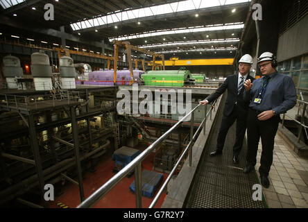 Der stellvertretende erste Minister John Swinney spricht mit dem Stationsleiter Lee Warren (rechts) in der Turbinenhalle während eines Besuchs im Kraftwerk Longannet in Fife. Stockfoto