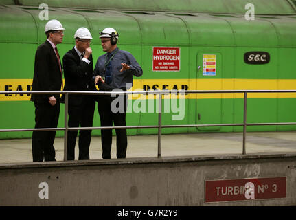 Der stellvertretende erste Minister John Swinney (Mitte) spricht mit dem Stationsleiter Lee Warren (rechts) in der Turbinenhalle während eines Besuchs im Kraftwerk Longannet in Fife. Stockfoto