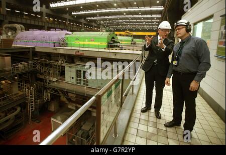 Der stellvertretende erste Minister John Swinney spricht mit dem Stationsleiter Lee Warren (rechts) in der Turbinenhalle während eines Besuchs im Kraftwerk Longannet in Fife. Stockfoto