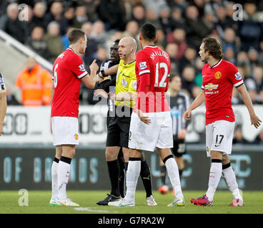 Schiedsrichter Anthony Taylor trennt die Manchester United's Jonny Evans und die Newcastle United Papiss Demba Cisse während des Barclays Premier League Spiels im St James' Park, Newcastle. Stockfoto