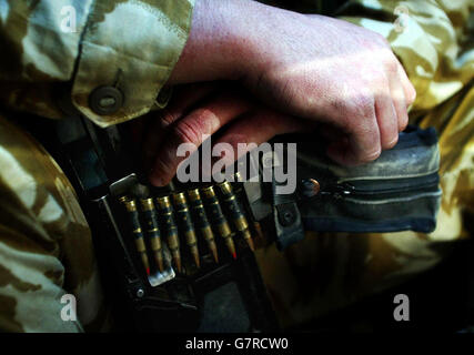 Ein Soldat hält sein Allzweck-Maschinengewehr in der Rückseite eines Land Rover, als er Basra, Südirak betritt. Stockfoto