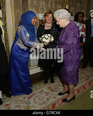 Königin Elizabeth II. Wird bei einem Empfang zum Commonwealth Day im Marlborough House im Zentrum von London mit Blumen aus Nurliyana Fatin Arfin überreicht. Stockfoto