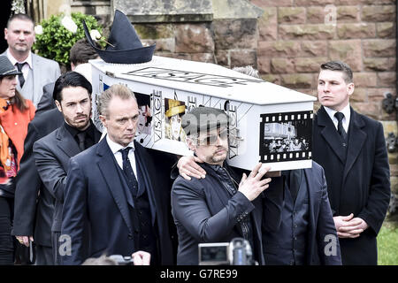 Der mit Visage dekorierte und mit Hut bedeckte Sarg von Steve Strange wird von Mitgliedern des Spandau Ballet, darunter Gary Kemp (Mitte) und Boy George (rechts), aus All Saints Church, Porthcawl, Wales, herausgebracht, wo die Beerdigung des Popstars der 80er Jahre stattfand. Stockfoto