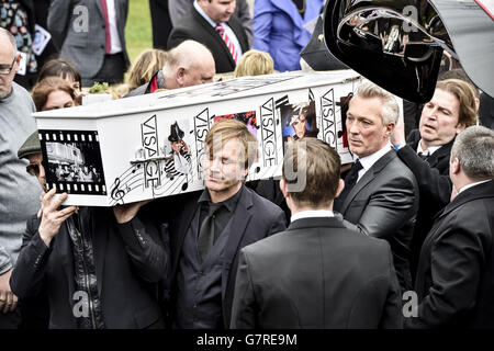 Der mit Visage dekorierte und mit Hut bedeckte Sarg von Steve Strange wird von Mitgliedern des Spandau Ballet, darunter Steve Norman (vorne rechts) und Martin Kemp (Mitte rechts), aus der All Saints Church, Porthcawl, Wales, herausgebracht, wo die Beerdigung des Popstars der 80er Jahre stattfand. Stockfoto