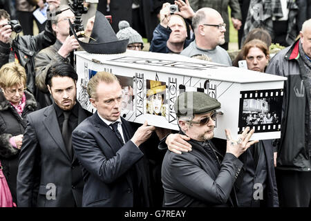 Der mit Visage dekorierte und mit Hut bedeckte Sarg von Steve Strange wird von Mitgliedern des Spandau Ballet, darunter Gary Kemp (Mitte) und Boy George (rechts), aus All Saints Church, Porthcawl, Wales, herausgebracht, wo die Beerdigung des Popstars der 80er Jahre stattfand. Stockfoto