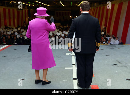 Königin Elizabeth II winkt den Besatzungsmitgliedern zu, während sie neben dem Kapitän Timothy Henry des Schiffes auf dem Flugzeuglift des HMS Ocean der Royal Navy auf dem HM Naval Base Devonport in Plymouth, Devon, steht. Stockfoto