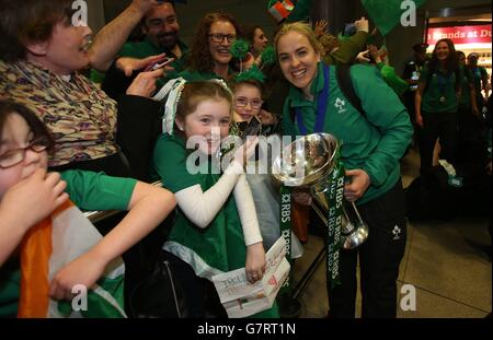 Irlands Rugby-Kapitän Niamh Briggs hält die Six Nations-Trophäe, während sie mit Fans feiert, als das Team am Flughafen Dublin ankommt, nachdem es die Six Nations-Trophäe bei einem 73-3-Sieg über Schottland in Glasgow gewonnen hat. Stockfoto