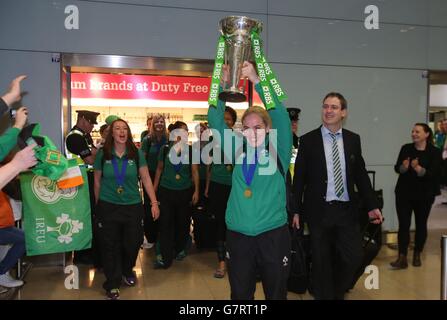 Irlands Rugby-Kapitän Niamh Briggs hält die Six Nations-Trophäe hoch, während sie mit Fans feiert, als das Team am Flughafen Dublin ankommt, nachdem es die Six Nations-Trophäe bei einem 73-3-Sieg über Schottland in Glasgow gewonnen hat. Stockfoto