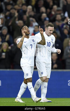 Der englische Raheem Sterling (links) feiert mit seinem Teamkollegen Wayne Rooney, nachdem er während des UEFA 2016 Qualifying, Gruppe E Spiel im Wembley Stadium, London, das dritte Tor des Spiels erzielt hat. Stockfoto