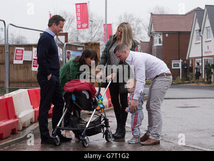 Premierminister David Cameron und seine Frau Samantha treffen die ersten Hauskäufer Robert Arron (rechts) und Kelly Jeffers (dritte rechts) und die Kinder Finlay (zweite rechts) und Regan im Wohnbauland Heritage Brook in Chorley, Lancashire, Wo sie das „Help to Buy“-Programm der Regierung genutzt haben, um ihr Haus zu kaufen. Stockfoto