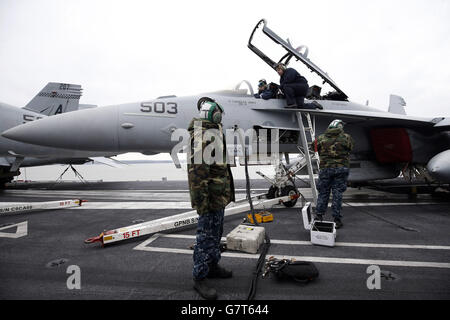 US-Marinepersonal arbeitet an Bord des US-Flugzeugträgers USS Theodore Roosevelt, der derzeit vor der britischen Südküste vor Anker liegt, da er zu groß ist, um in einen der wichtigsten Stützpunkte der Royal Navy zu gelangen, der Carrier, einer von zehn Flugzeugträgern der Nimitz-Klasse der US-Flotte, kam in Portsmouth an, Hampshire, gestern für einen fünftägigen Besuch. Stockfoto