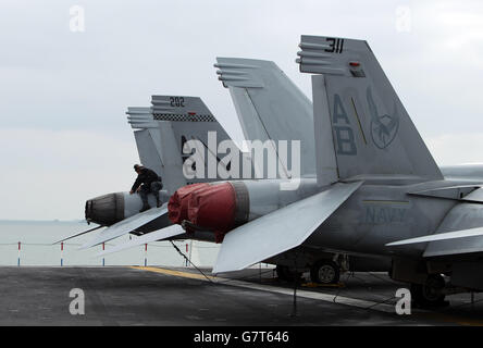 US-Marinepersonal arbeitet an Bord des US-Flugzeugträgers USS Theodore Roosevelt, der derzeit vor der britischen Südküste vor Anker liegt, da er zu groß ist, um in einen der wichtigsten Stützpunkte der Royal Navy zu gelangen, der Carrier, einer von zehn Flugzeugträgern der Nimitz-Klasse der US-Flotte, kam in Portsmouth an, Hampshire, gestern für einen fünftägigen Besuch. Stockfoto