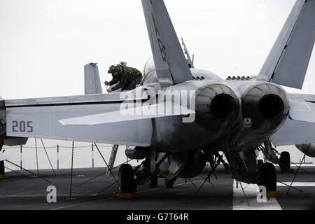 US-Marinepersonal arbeitet an Bord des US-Flugzeugträgers USS Theodore Roosevelt, der derzeit vor der britischen Südküste vor Anker liegt, da er zu groß ist, um in einen der wichtigsten Stützpunkte der Royal Navy zu gelangen, der Carrier, einer von zehn Flugzeugträgern der Nimitz-Klasse der US-Flotte, kam in Portsmouth an, Hampshire, gestern für einen fünftägigen Besuch. Stockfoto