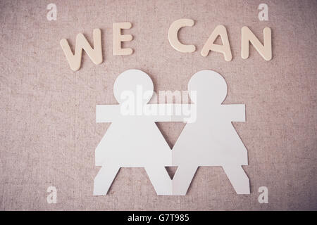 Paper Dolls Hand in Hand mit 'WE CAN' Wort Stockfoto