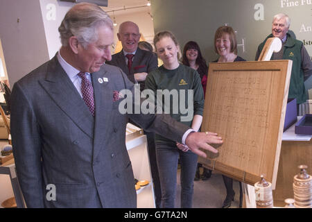 Der Prinz von Wales sieht sich eine Tafel an, als er Peter Hall & Son, die Möbelhersteller von Bespoke in Kendal, Cumbria, besucht. Stockfoto