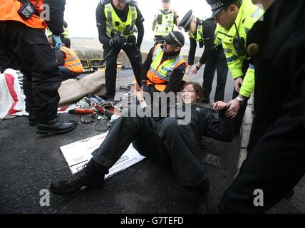 Anti-Trident-Demonstranten, die sich mit Rohrleitungen verbunden haben, haben sie von der Polizei am Südeingang des Marinestützpunktes Clyde, Faslane, abgeschnitten. Stockfoto