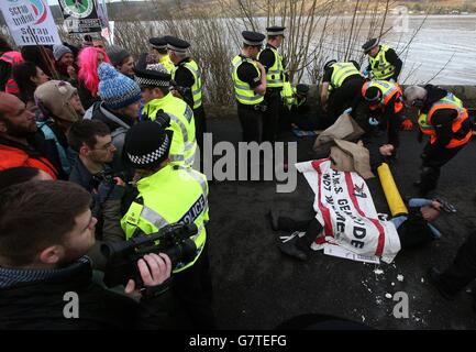 Anti-Trident-Demonstranten, die sich mit Rohrleitungen verbunden haben, haben sie von der Polizei am Südeingang des Marinestützpunktes Clyde, Faslane, abgeschnitten. Stockfoto