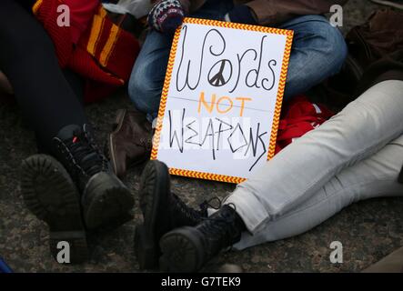 Anti-Trident-Demonstranten sitzen auf der Straße am Eingang des Nordtors am HM Naval Base Clyde, Faslane. Stockfoto