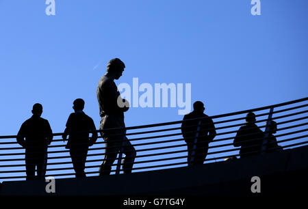 Die Silhouette des ehemaligen englischen Kapitäns Bobby Moore ist vorbei Fans außerhalb des Wembley Stadions Stockfoto
