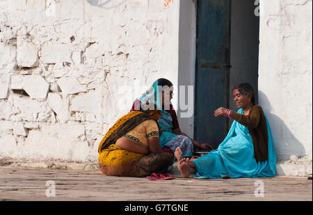 Nicht identifizierte indische Frauen sitzen und plaudern auf einer weißen Haus Veranda Stockfoto