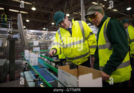 Schatzkanzler George Osborne (links) trifft sich mit Mitarbeitern und besucht die Produktionslinie des Getränkekonzerns Britvic in Pudsey, West Yorkshire, wo er eine Rede vor den Arbeitern hielt. Stockfoto