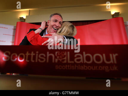 Jim Murphy, der Vorsitzende der schottischen Labour-Partei, umarmte sich von Margaret Curran Shadow, dem schottischen Staatssekretär für Schottland, nachdem er vor einer Audienz in den Glen Halls in Neilston gesprochen hatte, wo er offiziell den schottischen Parlamentswahlkampf seiner Partei startete. Stockfoto