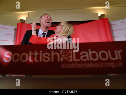 Jim Murphy, der Vorsitzende der schottischen Labour-Partei, umarmte sich von Margaret Curran Shadow, dem schottischen Staatssekretär für Schottland, nachdem er vor einer Audienz in den Glen Halls in Neilston gesprochen hatte, wo er offiziell den schottischen Parlamentswahlkampf seiner Partei startete. Stockfoto