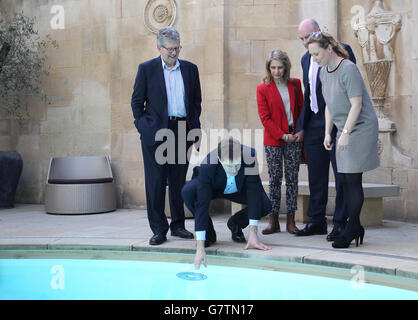 Nick Clegg, der Führer der Liberaldemokraten, greift nach unten, um die Wassertemperatur während eines Besuchs im Thermae Bath Spa in Bath zu spüren, als Teil seines Parlamentswahlkampfs 2015, als liberaldemokratische Kandidaten, Steve Bradley, für Bath, (rechts), Wera Hobhouse für North East Somerset (dritte links) Und der ehemalige liberaldemokratische Abgeordnete für Bath, Don Foster (links), der sich niedergeschlagen hat, und Charlotte Hanna (rechts) von Thermae Bath Spa, schauen Sie sich an. Stockfoto