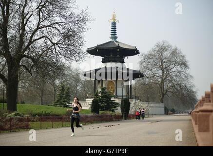 Ein Jogger, der an der Friedenspagode im Battersea Park, London, vorbeiläuft, während das warme Wetter in ganz Großbritannien anhält Stockfoto