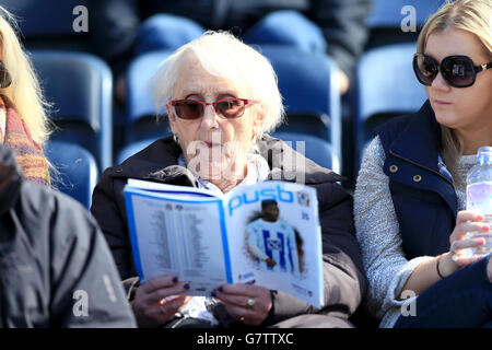 Fans von Coventry lesen das Spieltagsprogramm vor dem Spiel auf den Tribünen. Stockfoto