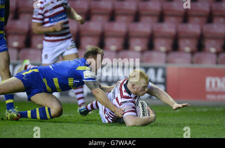 Wigan Warriors Liam Farrell versucht beim ersten Spiel der Utility Super League im DW Stadium, Wigan, an Micky Higham von Warrington Wolves vorbei. Stockfoto