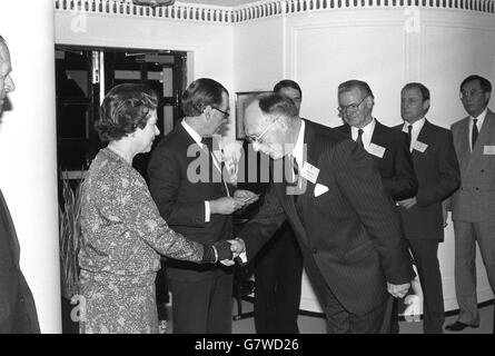 Königin Elizabeth II, beobachtete den Herzog von Edinburgh, trifft an Bord von Britannia die Träger des Queen's Award 1988 für Industrie für Export und Technologie. Neben der Königin liest Konteradmiral Sir Paul Greening, Hausmeister, die Namen vor. Stockfoto