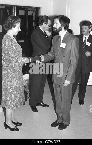 Königin Elizabeth II., die den Herzog von Edinburgh beobachtete, trifft John Croxford, einen der Träger des Queen's Award 1988 für Industrie für Export und Technologie, an Bord von Britannia. Neben der Königin liest Konteradmiral Sir Paul Greening, Hausmeister, die Namen vor. Stockfoto