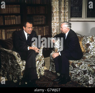 Richard Nixon, der amerikanische Präsident, hört zu, wie Großbritanniens Premierminister Harold Wilson, die Hände um sein Knie geklammert, auf einem Sitz vor dem massiven Kamin in der Great Hall of Chequers, dem offiziellen Wohnsitz des Premierministers in Buckinghamshire, spricht. Herr Nixon war direkt vom Flughafen Heathrow nach Chequers gefahren, wo er auf seiner Europa-Tour ankam. Stockfoto